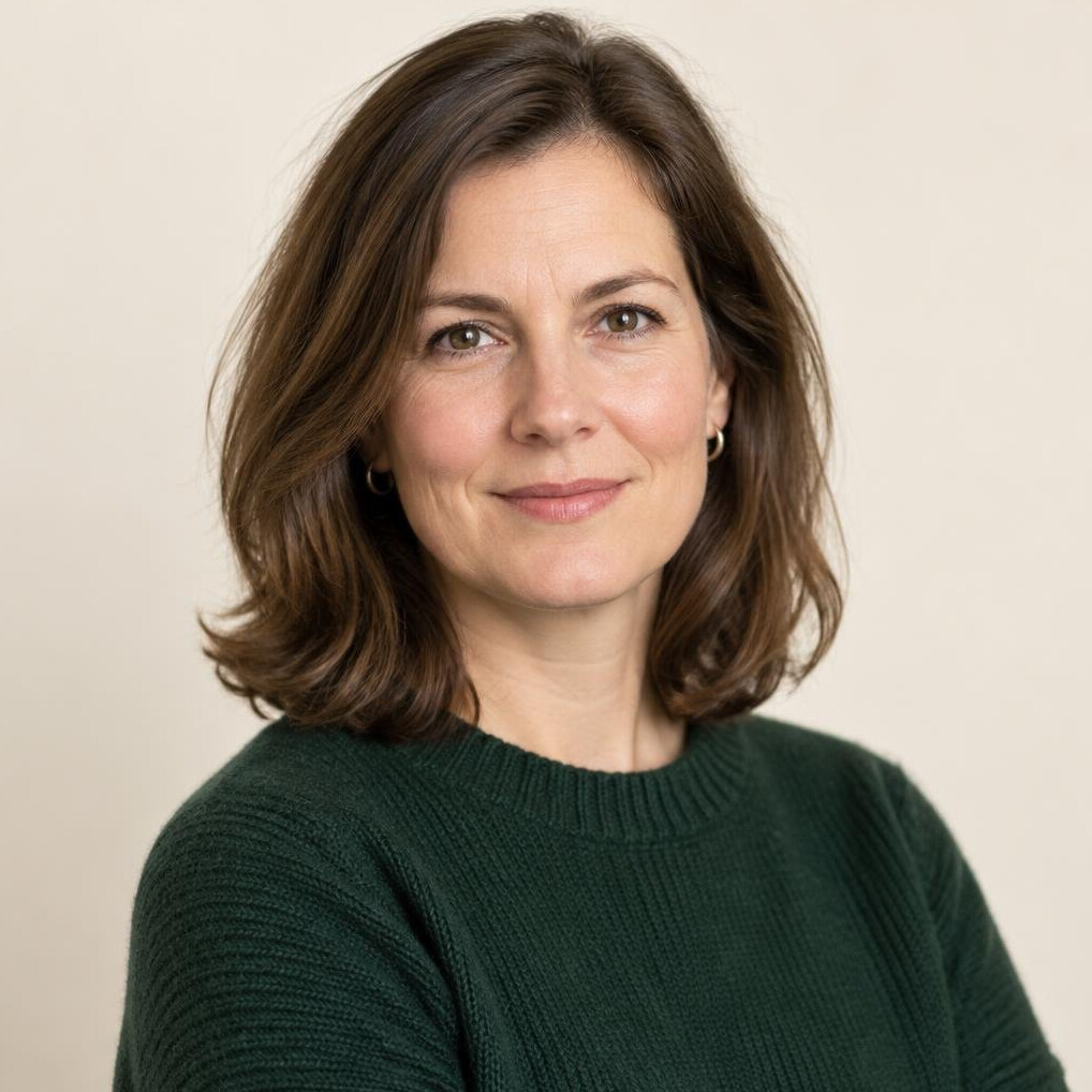 Portrait of a woman in her forties with shoulder-length brown hair in a neutral studio