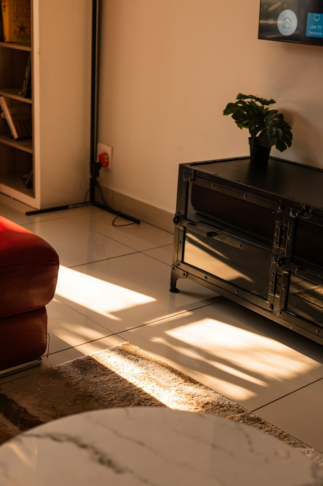 Television screen glowing in a dim living room with an empty armchair