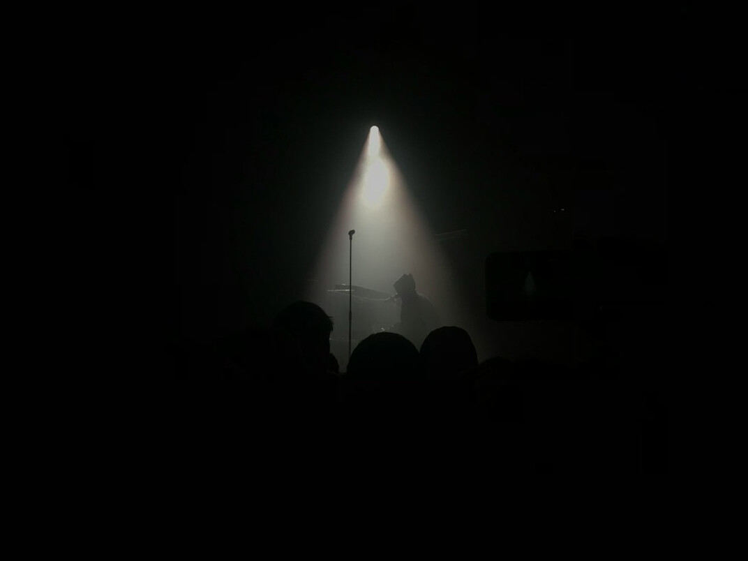 Spotlight on an empty stage with a single microphone stand